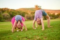 Bet you cant do this. Portrait of two little girls doing handstands on the grass outdoors. Royalty Free Stock Photo