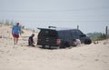 Bethany Beach, Delaware, U.S.A - August 5, 2023 - A group of men digging a black truck that was stuck in the sand