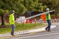 workers are carrying a metal wire fence panel in a construction site. Royalty Free Stock Photo