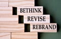 BETHINK REVISE REBRAND - words on wooden blocks on dark green background