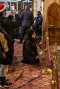Believer woman kneels and prays in front of the altar in the main hall of the Church of Nativity in Bethlehem in the Palestinian