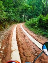 Beton lane street road off in jungle forest rain trees palms green earth dirt mudder scooter bike mountain chiang mai Royalty Free Stock Photo