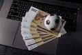 Bets, sports betting, bookmaker. Soccer ball and money on a laptop`s keyboard close-up Royalty Free Stock Photo