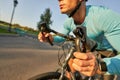 Better, faster. Close up shot of hands on handlebar of professional cyclist riding his road bike in the park