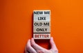 Better new me symbol. Men hand. Wooden blocks with words `new me like old me only better`. Beautiful orange background, copy spa