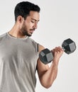Better sore than sorry. Studio shot of a muscular young man exercising with a dumbbell against a white background. Royalty Free Stock Photo