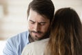 Compassionate millennial man hugging young suffering woman sharing her grief Royalty Free Stock Photo