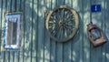 Betty lamp and spinning wheel in the background of the old log-house wall with sign nomber one. Rural retro still life. Royalty Free Stock Photo