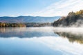 Mountain lake with forested shores on a misty autumn morning Royalty Free Stock Photo