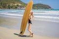 Beuatiful surfer girl making preparation for a surf session