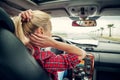 Beutiful blond girl comb her hair with a rearview mirror in car Royalty Free Stock Photo