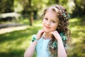 Beutiful little girl smiling looking at camera in the blooming spring garden