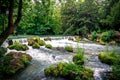 A beutiful waterfall with lots of green around it.