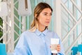 Beautiful Woman Drinking Coffee From Coffee Recyclable Cardboard Takeaway Cup at Street Cafe. Mug With Copy Space. Empty