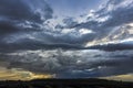 Beveled plowing field by summertime under dramatic cloudy sky sunset time, beautiful nature rural landscape Royalty Free Stock Photo