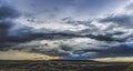 Beveled plowing field by summertime under dramatic cloudy sky sunset time, beautiful nature rural landscape Royalty Free Stock Photo