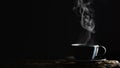 Beverage background of hot coffee, tea or chocolate in black cup on wooden plank in dark background