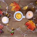 Beverage, hot drink in a mug, leaves, foliage, garland, candles, top view of wooden table, good weather concept, outdoor tea party Royalty Free Stock Photo