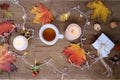 Beverage, hot drink in a mug, leaves, foliage, garland, candles, top view of wooden table, good weather concept, outdoor tea party Royalty Free Stock Photo