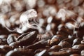 Bevergae background of a roasted coffee bean on background of coffee beans with aromatic smoke Royalty Free Stock Photo