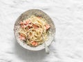 Bevette creamy pasta with baked trout on a light background, top view