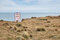 Beware of cliff warning sign, coastal landscape