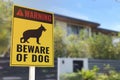 A Beware of Dog Sign in front of a gated home. Warning to visitors or burglars. Security and protection in a residential home