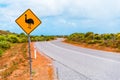 Yellow warning sign with emu on winding asphalt road in Australia Royalty Free Stock Photo