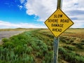 A beware of road damage sign on lonely road in Wyoming. Royalty Free Stock Photo