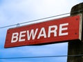 Beware sign in white lettering on red background