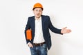 Bewildered businessman in dark suit, protective hardhat holding case with instruments or toolbox and pointing hand aside Royalty Free Stock Photo