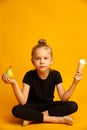 Puzzled little dancer choosing between pear and ice cream Royalty Free Stock Photo
