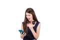 Bewildered young woman with headphones looking shocked, mouth open at her smartphone, isolated on white background