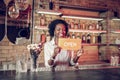 Bewitching beaming young-adult Afro-American bartender holding open sign in hands