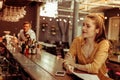 Bewitching lady with red hair sitting at the bar counter Royalty Free Stock Photo