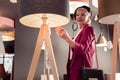 Bewitching stylish elderly female designer choosing new interior lamp