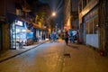 Karakoy street and small shops with shiny lights at night time and some people tourists walking around for traveling sightseeing