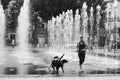 Portait of man with dogs running in the fountain on the main place in the city