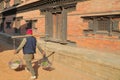 BHAKTAPUR, NEPAL: A local seller carrying vegetable in baskets at Durbar Square