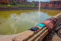 BHAKTAPUR, NEPAL - NOVEMBER 04, 2017: Close up of traditional urban scene with an artificial pond with ducks swimming