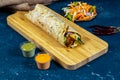 Bhuna Beef shawarma Wrap with salad dip and sauce wooden board side view of fastfood