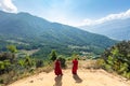 Bhutan, October 26, 2021: Two Buddhist monks look out over the mountainous landscape of Bhutan near the Tiger Nest Monastery. The