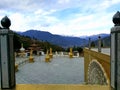 Bhutanese architects with statues and chorten with background green mountains with little white snow