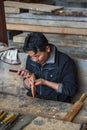 Bhutanese artisan carving a wooden vajra , Bhutan