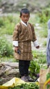 Bhutanese boy wear a traditional coat , stand beside chili , Bhutan