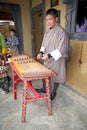 Bhutanese musician is playing a yangqin, Bhutan