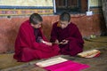 Bhutanese novice monks help each other during the daily study , Bhutan