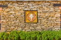 Bhutanese stone boundary wall with colorful carving wood artwork, green bush and copy space for your text. Bhutan style house deco Royalty Free Stock Photo