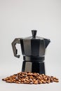 Bialetti moka pot. Coffee maker and coffee beans on gray background