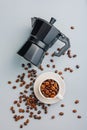 Bialetti moka pot. Coffee maker and coffee beans in mug on gray background. Top view Royalty Free Stock Photo